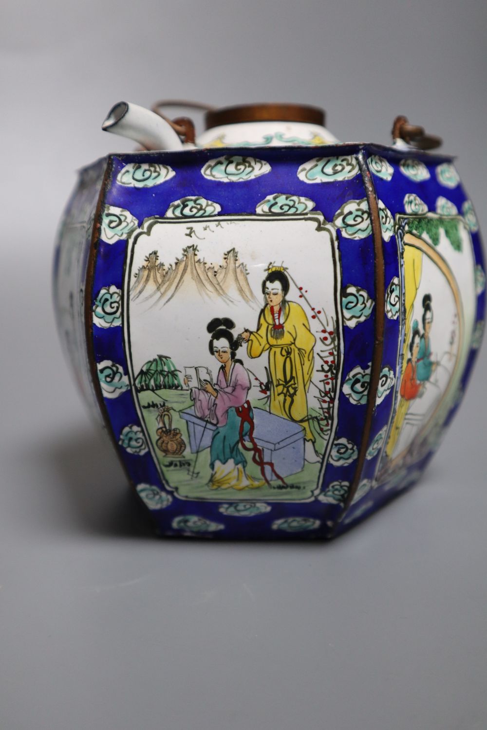 A polychrome-enamelled ceramic wine pot and cover with hexagonal outer case decorated figures in reserves